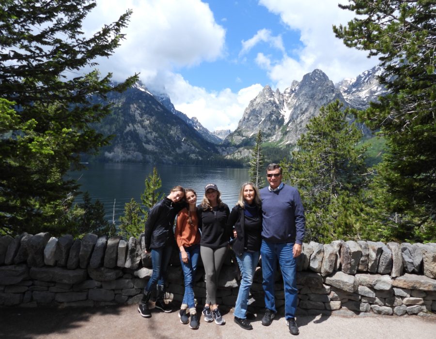group of visitors walking along trail with Grand Teton mountains