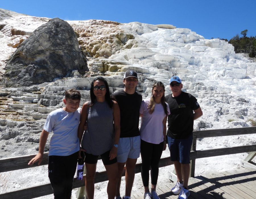 group of visitors posing near snowy mountain landscape