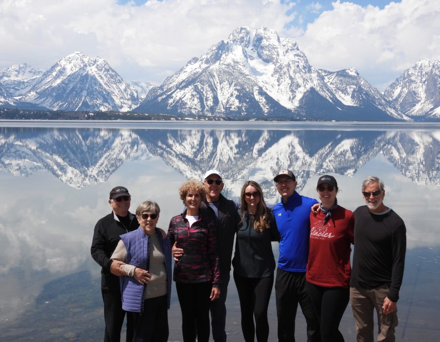 group of visitors posing with Grand Teton mountains in background